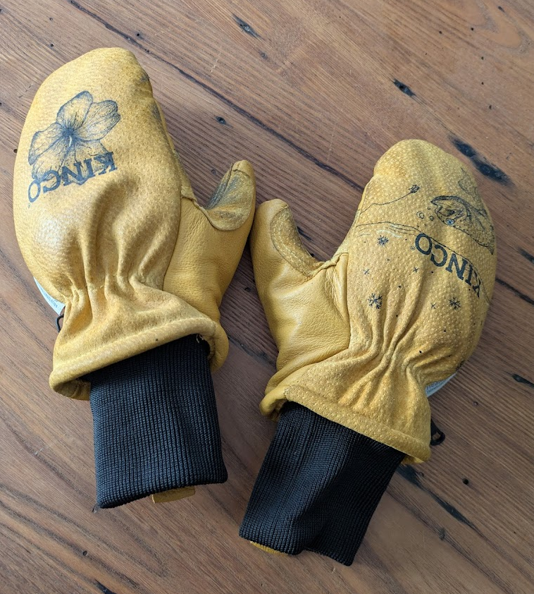 Kinco Ski Goves with handdrawn art on a wooden table.